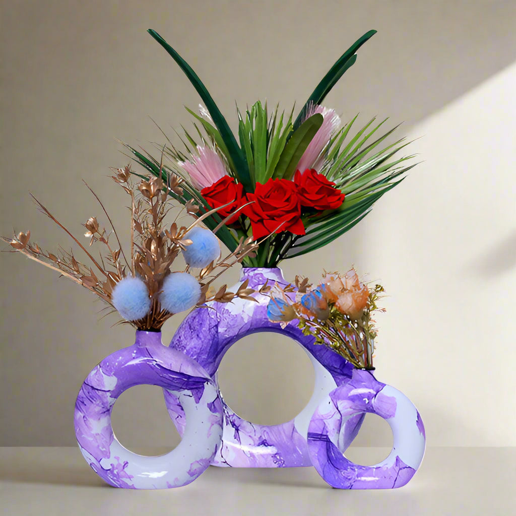 Purple marble vase with floral arrangement on a white background